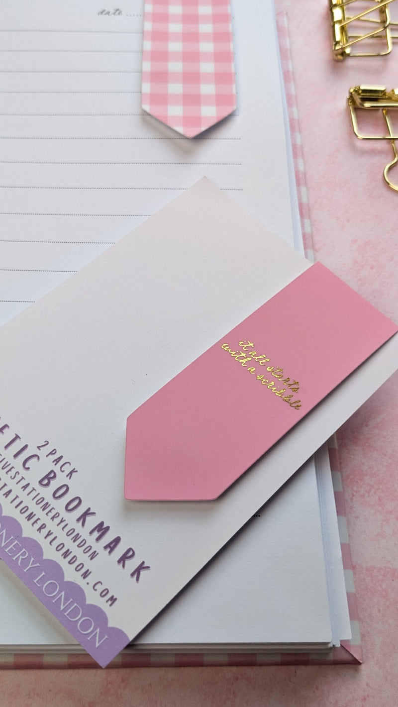 Pink checkered bookmarks with gold text on a white background