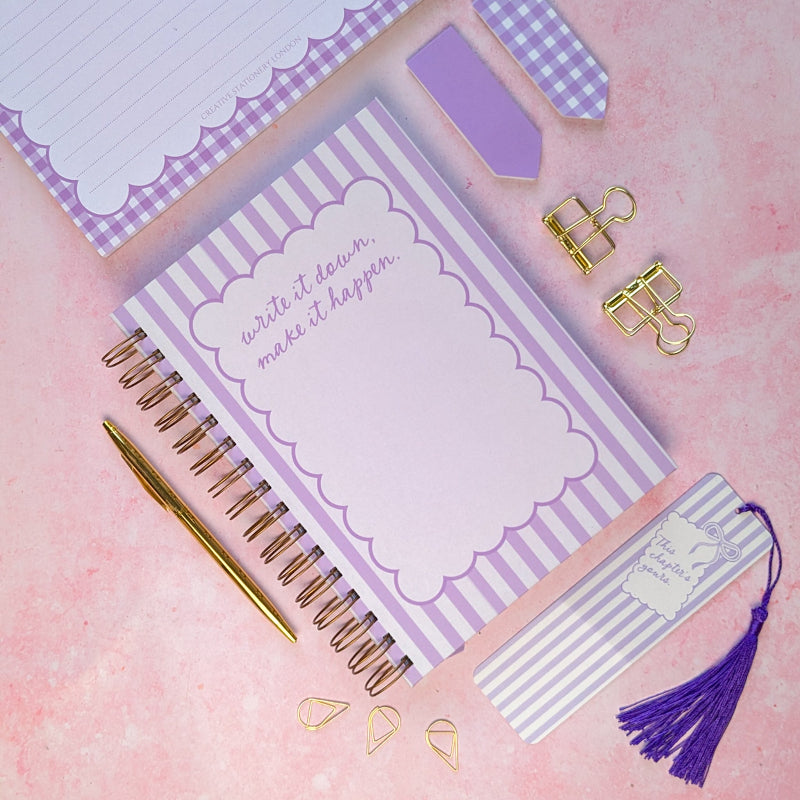 Purple notebook with decorative elements on a pink background