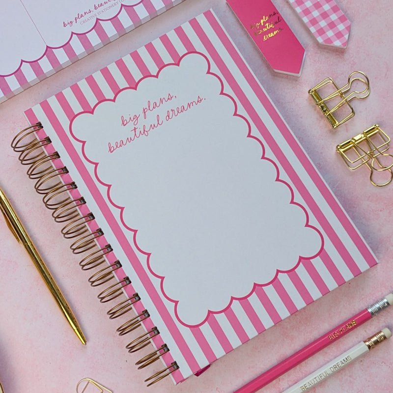 Pink notebook with decorative elements on a pink background
